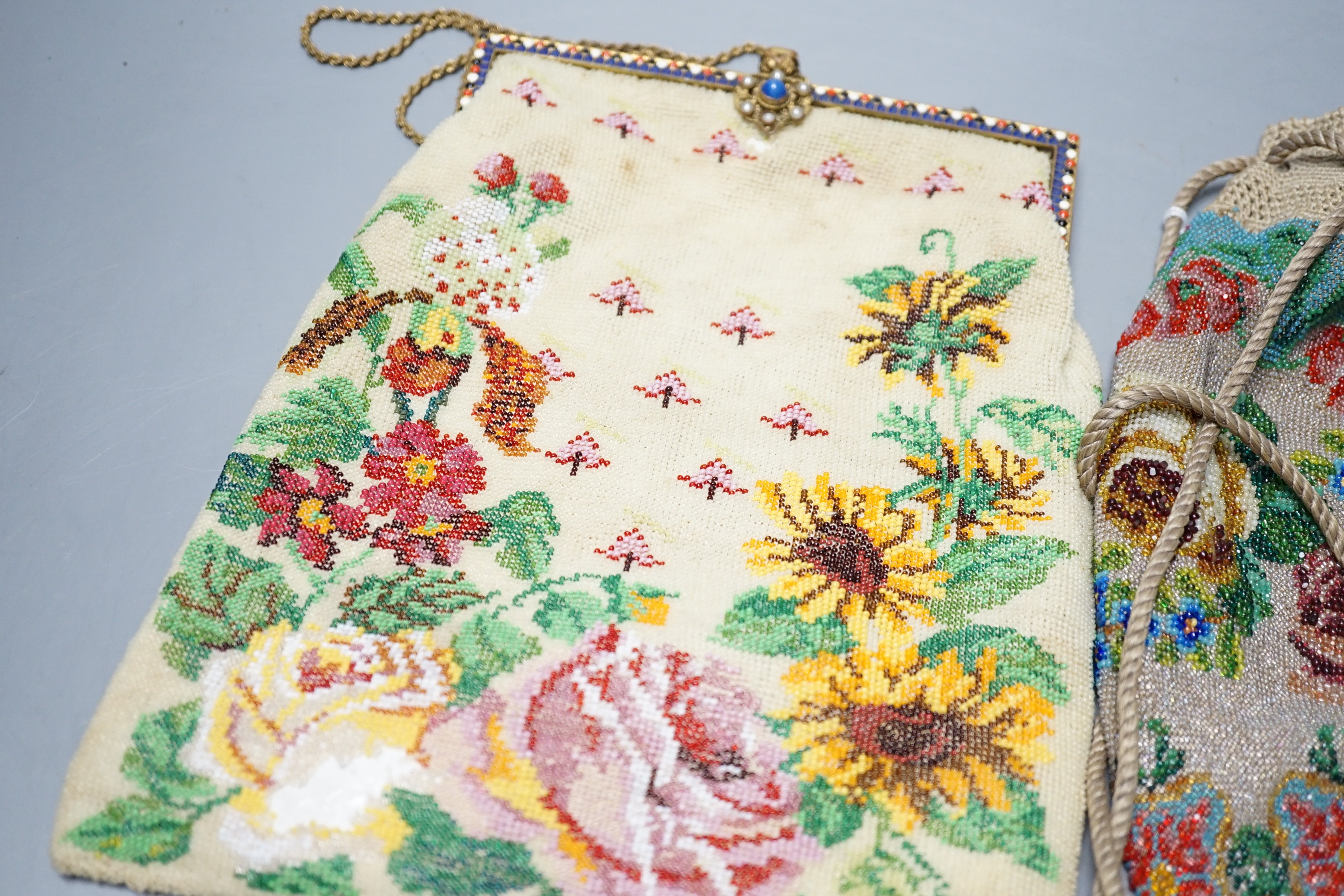 A 19th century framed beaded bag, designed with roses and garden flowers and another similar floral beaded drawstring bag, framed bead bag 21.5 cms high including clasp